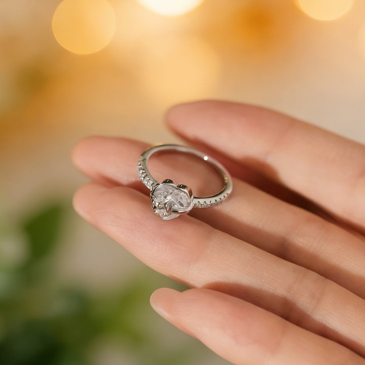 Silver heart and bow ring held in hand showing setting details
