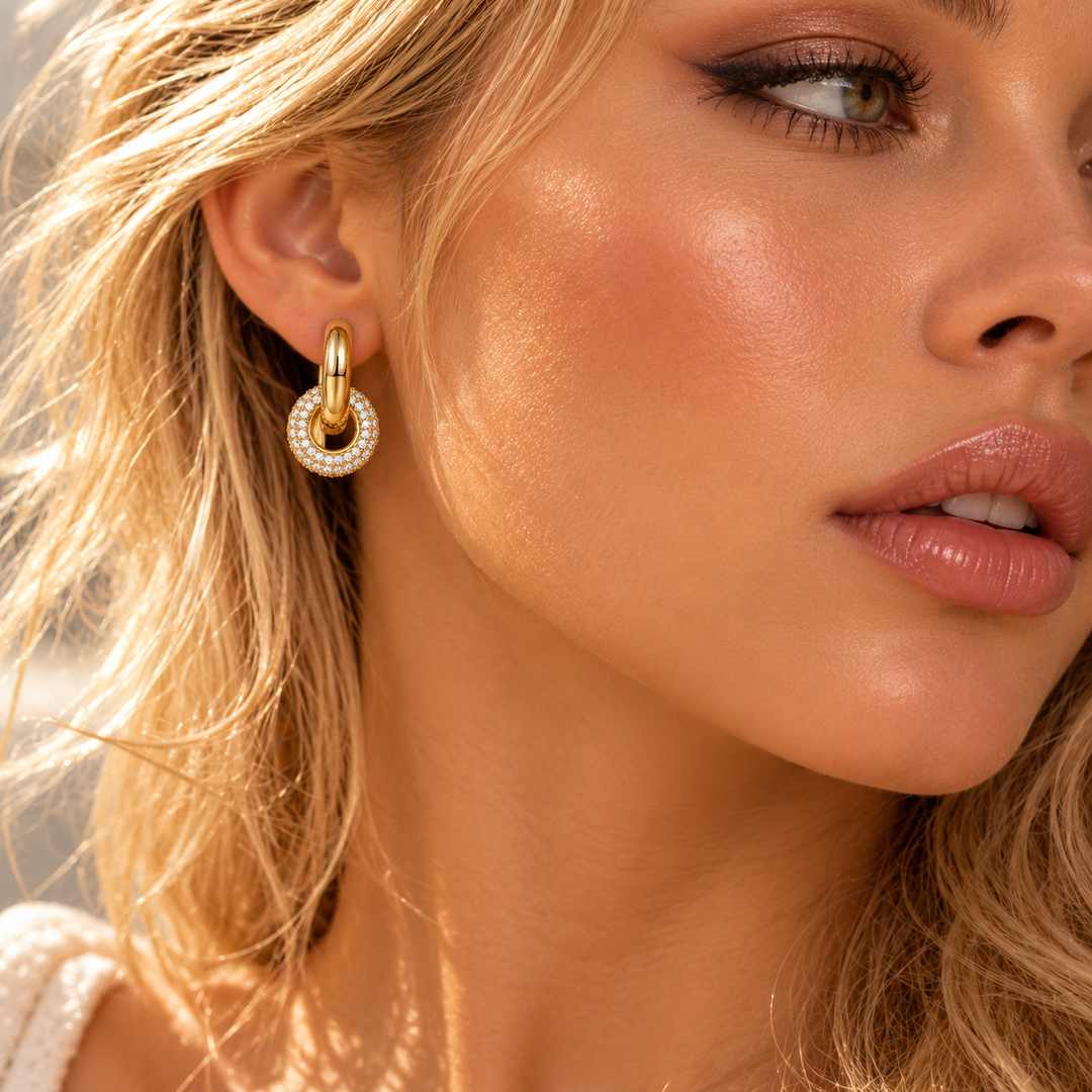 Model wearing a gold pave halo drop hoop earring