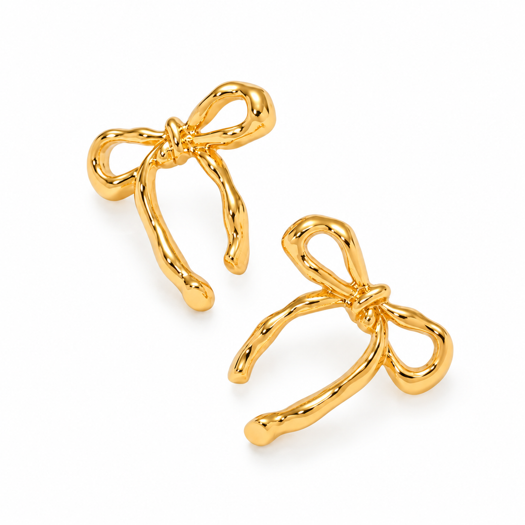 Pair of polished gold sculpted bow earrings on white background