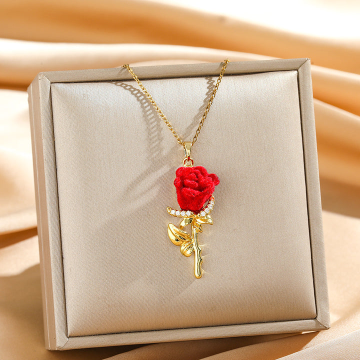Gold and red rose necklace displayed on a jewelry tray