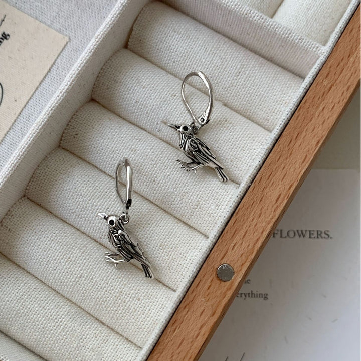 Silver raven earrings in a jewelry tray